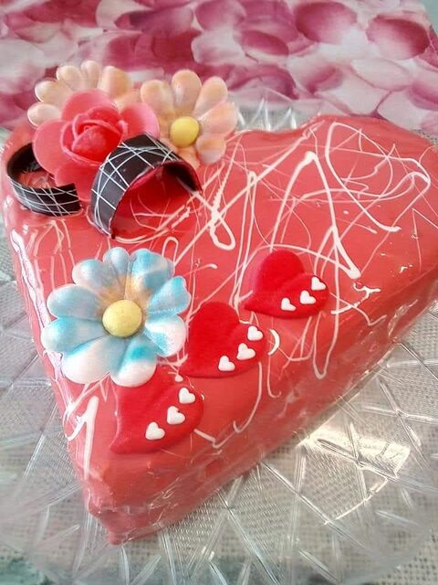 Torta gelato rossa a forma di cuore con fiori decorativi