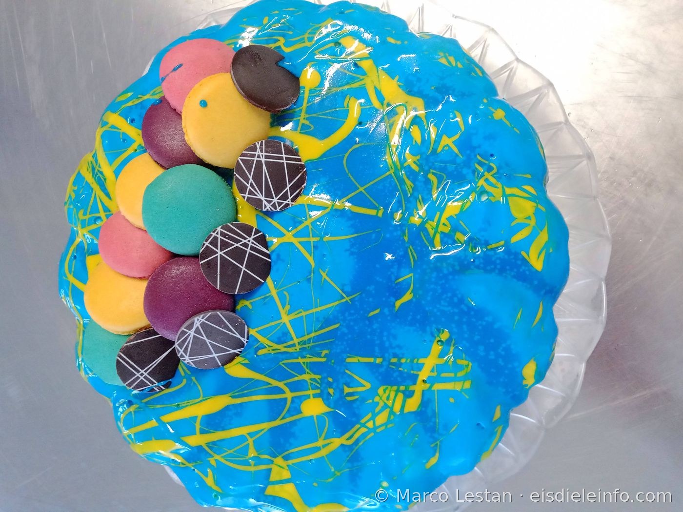 Gelbe Eistorten-Dekoration mit dekorativen Schmetterlingen und lila Blumen aus Zuckerpaste