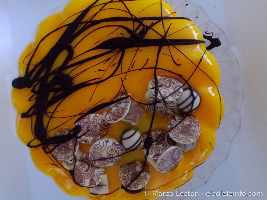 Orange Eistorte mit gezeichneten Schokoladendekoren und Ganache