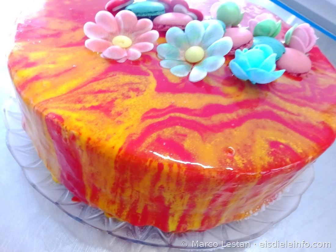 Eistorte mit rosa-orange marmorierter Glasur, Blumen und Macarons