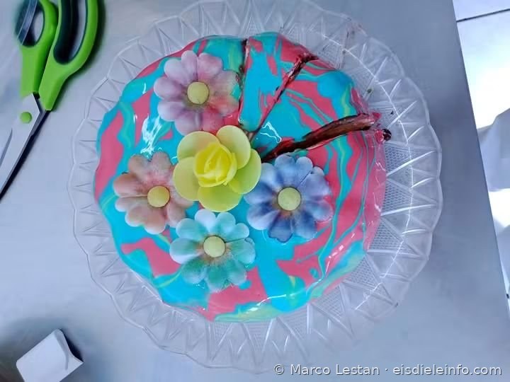 Eistorte mit marmorierter Glasur in Türkis und Rosa und bunten Blumen