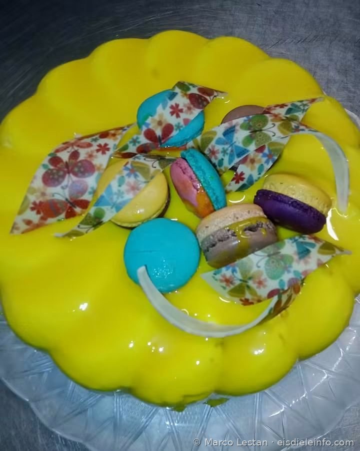 Eistorte mit gelber Glasur, bunten Macarons und Schmetterlingsdekor