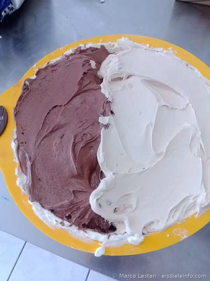 Schicht aus Schokoladencreme und weißer Creme in der gelben Silikonform während der Zubereitung