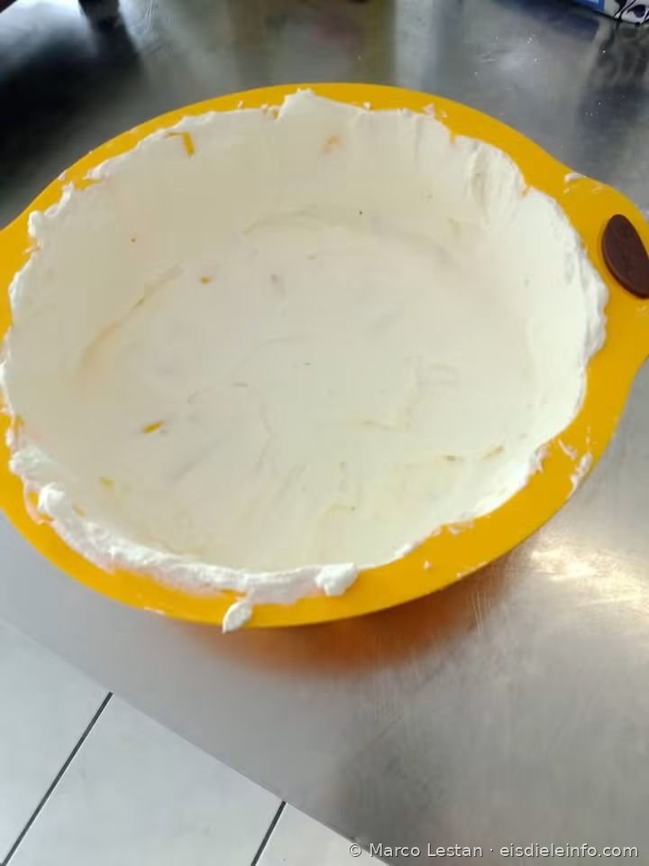 Schicht weißer Creme in der gelben Silikonform während der Zubereitung